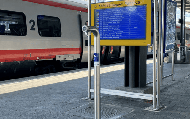 Swiss railways water refill stations at a train platform, featuring a water refill station and departure board.