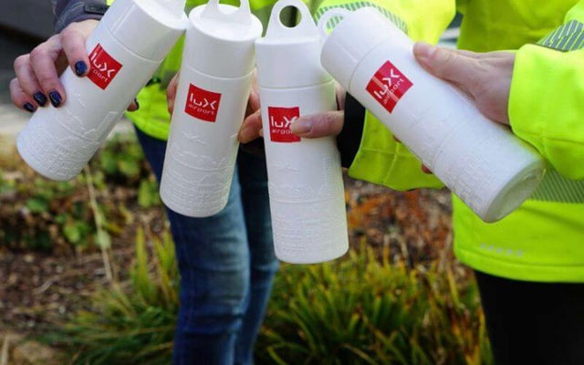 Eco-friendly water bottles promoting sustainable drinking water lux-airport in a vibrant outdoor setting.