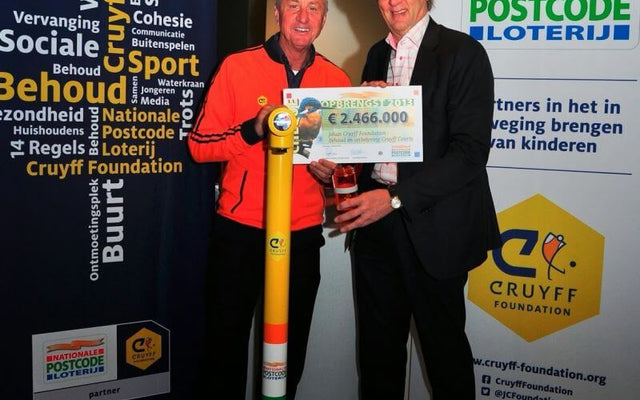 Johan Cruijff water initiative event with participants holding a check donation for the Cruyff Foundation.