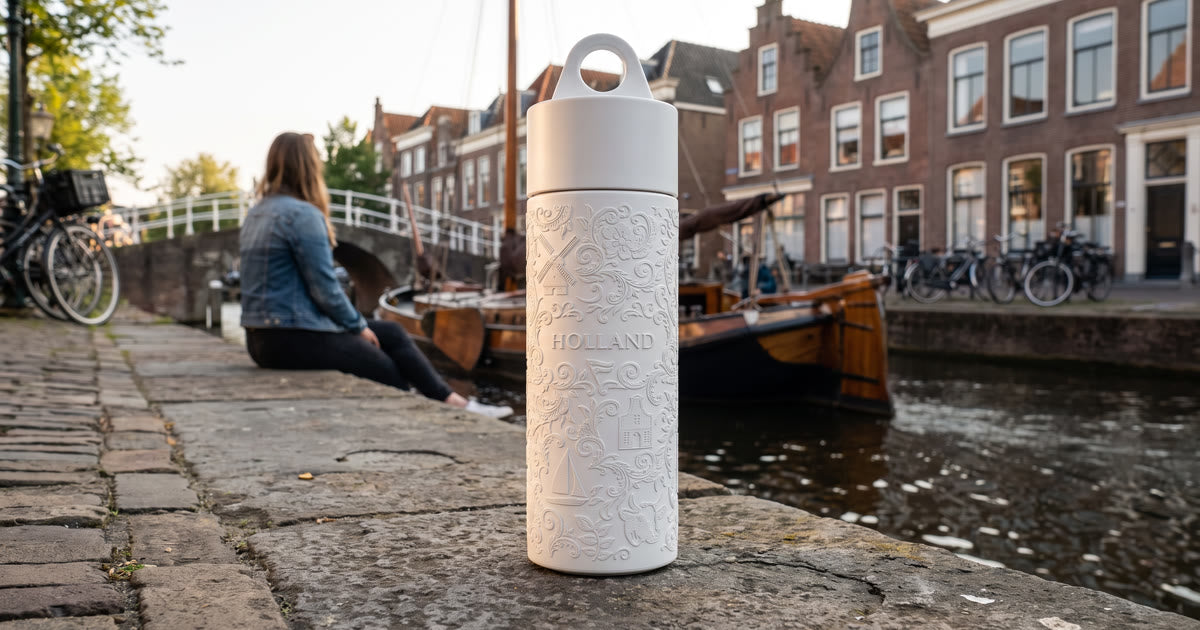 Join the Pipe Holland reusable sugarcane bottle on a canal quay in a Dutch town at golden hour