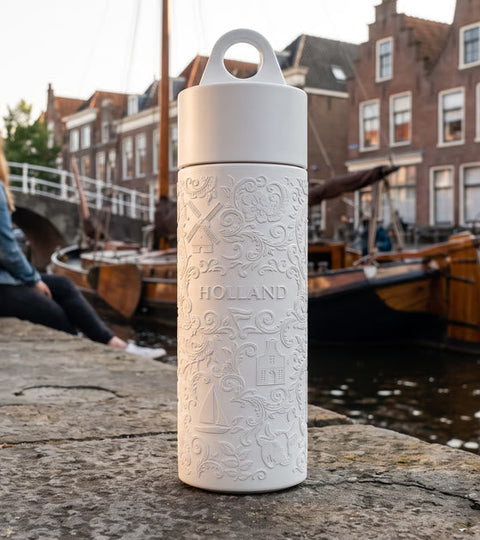 Join the Pipe Holland reusable sugarcane bottle on a canal quay in a Dutch town at golden hour
