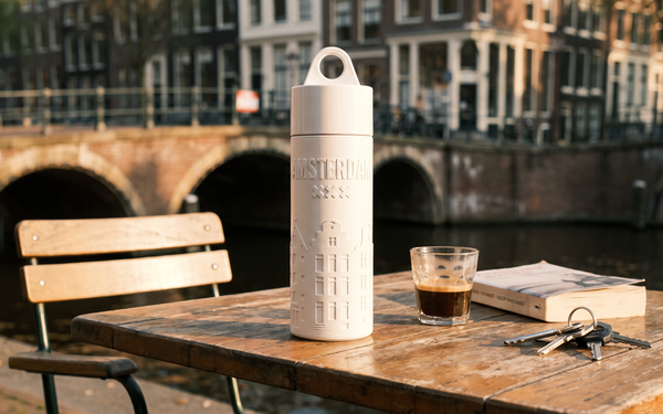 Join the Pipe Amsterdam reusable sugarcane water bottle on a canal-side cafe terrace at golden hour